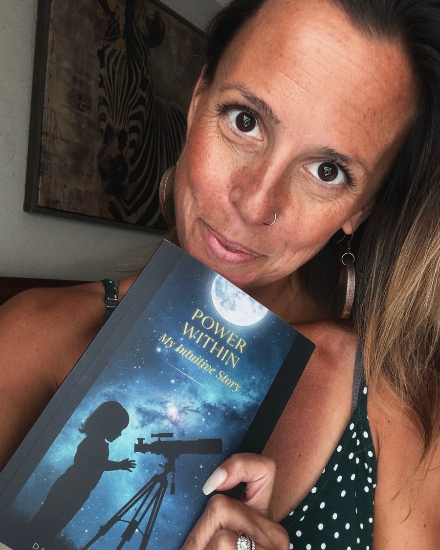 Danielle Irene holding her memoir, Power Within